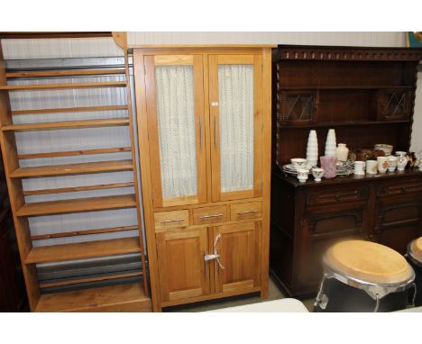 A modern light oak display cabinet fitted three drawers