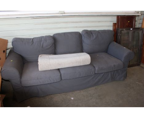 A grey upholstered three seater sofa