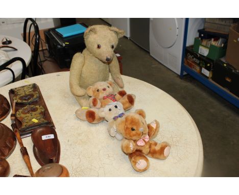 A vintage teddy bear together with three other teddy bears
