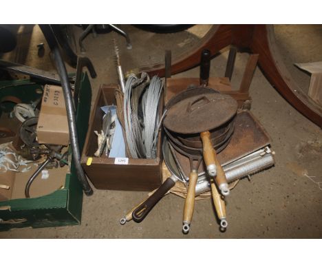 A set of scales and a collection of cast iron cooking pans, a press, reels of wire etc
