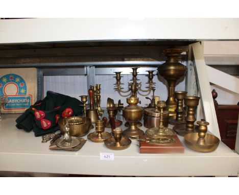 A collection of various brassware to include oil lamps, candelabra, bells and a Boy Scouts hat