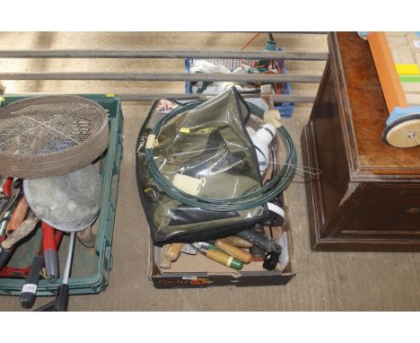 A box containing various garden hand tools, a table lamp and a reel of wire etc