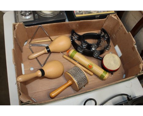 A box containing various musical instruments to include tambourine, maracas etc.