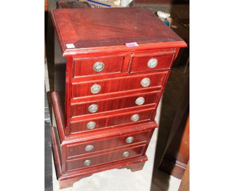 A small reproduction chest of two short over four long drawers, on bracket feet. 31" high