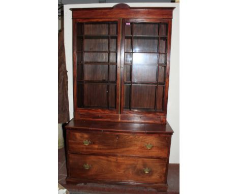 A 19th Century mahogany bookcase enclosed by a pair of glazed doors over two short drawers, the lower part with a slide and t