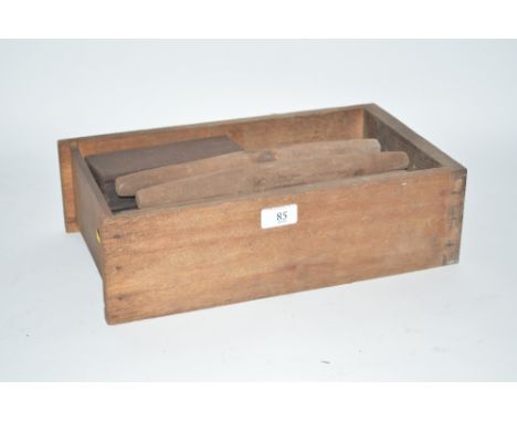 A wooden box containing various vintage sharpening stones