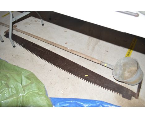 A large Vintage cross-cut saw and a long handled ladle
