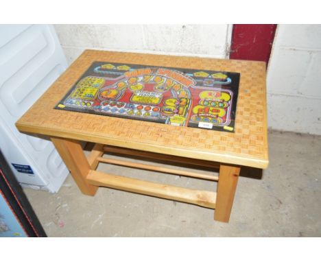 An occasional table, the top inset with a slot machine panel