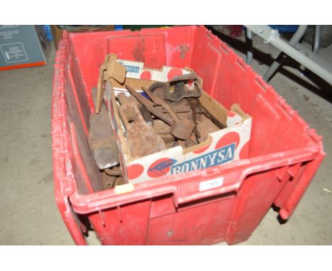 A box containing various axe heads, weights, shears etc.