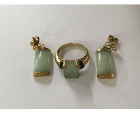 A pair of jade earrings with gold mounts and a gold ring with jade inset