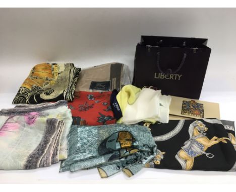 A collection of mixed designer scarves including Burberry, Christian Lacroix, Hermes etc in a Liberty retail bag.