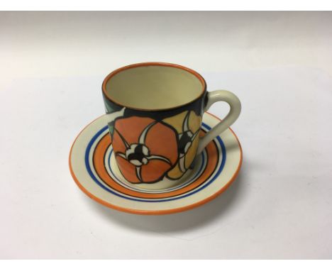 A Clarice Cliff coffee can and saucer decorated with flowers and foliage