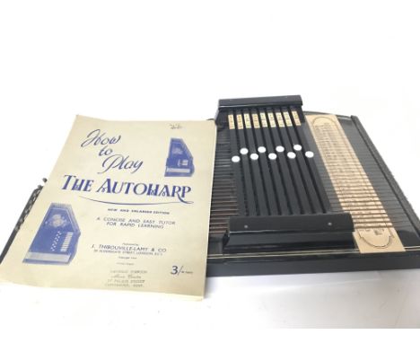 A Vintage Autoharp with a book of instructions.