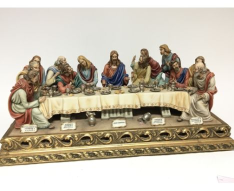A large Capodimonte ceramic figure group of the last supper on a gilt scroll base signed. 63x30cm.