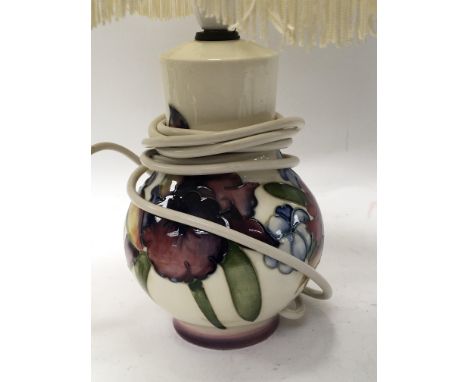 A Pre 1953 Moorcroft table lamp decorated with flowers on a white ground. Height 44cm fitted for electric and with a modern w