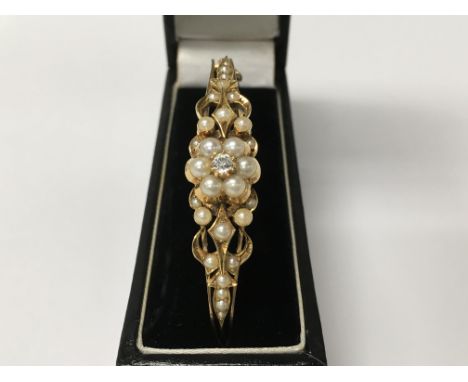 A 14 ct gold bangle inset with diamond surrounded with pearls in floral form
