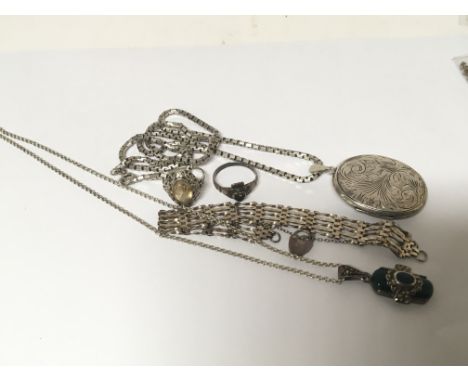 A collection of silver jewellery a locket and chain gate bracelet necklace and rings.