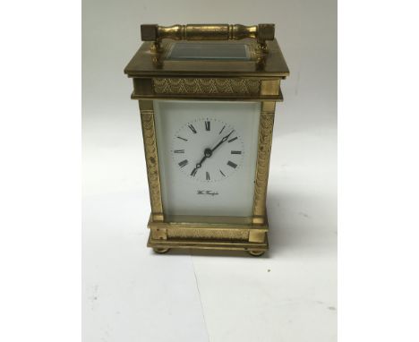 A brass cased carriage clock the enamel dial with Roman numerals