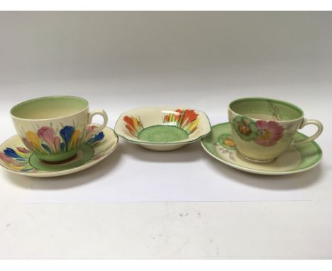 A collection of Clarice Cliff comprising crocus cups and saucer dish together with rodanthe cup and Saucer