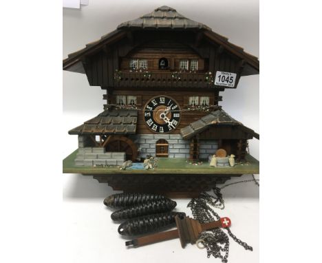 A wooden cuckoo clock, the dial with Roman numerals with Swiss musical movement