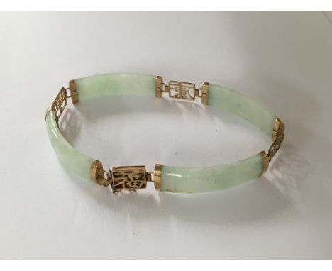 A jade bracelet with gold mounts