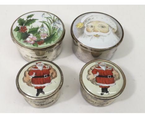 Four silver trinket boxes, each bearing Christmas scene