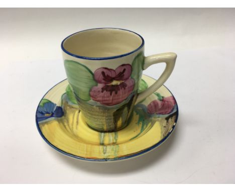 A Clarice Cliff coffee can and saucer decorated with pansy