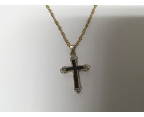 A 9carat gold cross pendent set with blue sapphire with an attached 9carat gold chain total weight 4g