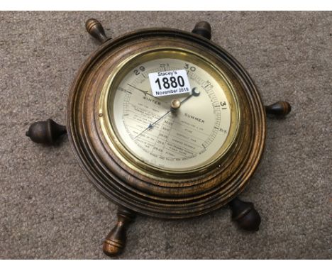 A small barometer in the shape of a ships wheel
