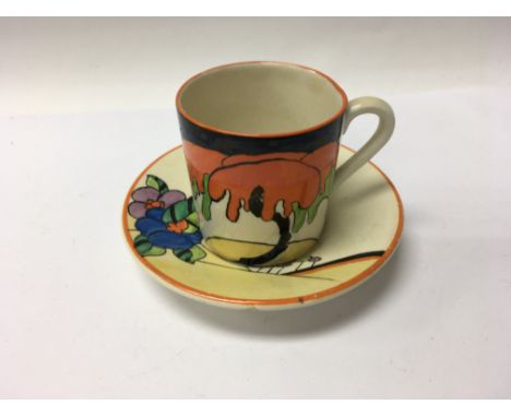 A Clarice Cliff coffee can and saucer decorated with flowers and foliage