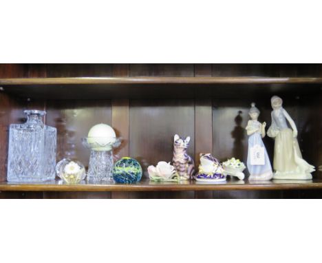 A Royal Crown Derby paperweight in the form of a frog, another as a cat, a Lladro figure of a girl holding flowers, a Nao fig