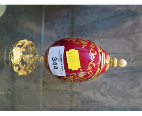 Sankyo ornamental musical egg trinket box with gilt painted and floral decoration on a gilt pedestal base