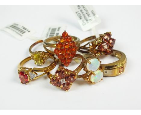 A collection of seven 9ct gold stone set rings to include a sapphire and diamond example, a fire opal cluster ring, a sphene 