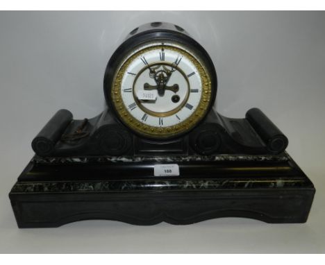 A Victorian black slate and variegated stone mantel clock with brocot escapement, white enamel dial and Roman numerals, a flu