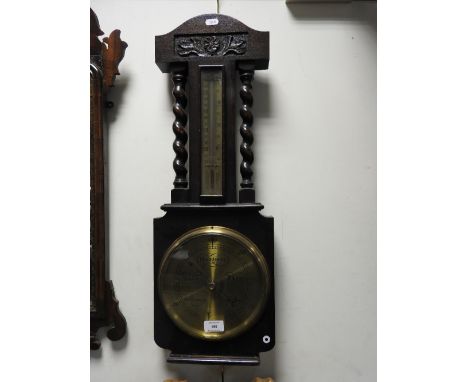 An early 20th century oak cased barometer and rain gauge