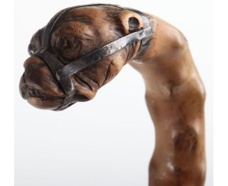 Two dog head walking sticks, one with screw off head in the form of a Labrador, the other with muzzled boxer type dog on natu