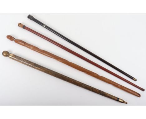 A walking stick billiard cue, with a tribal style carved head cane, an ebonised cane, another cane with screw release top rev