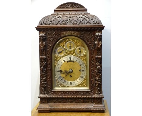 An early-20th century musical bracket clock, the heavily-carved oak domed case with arched door and pierced side panels, the 