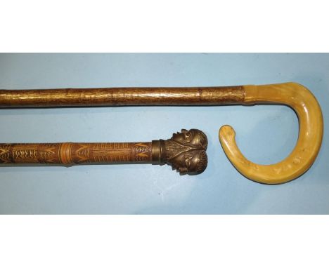 A carved bamboo staff with metal double-headed figural terminal, 167cm high, together with a horn-handled walking stick, (2).