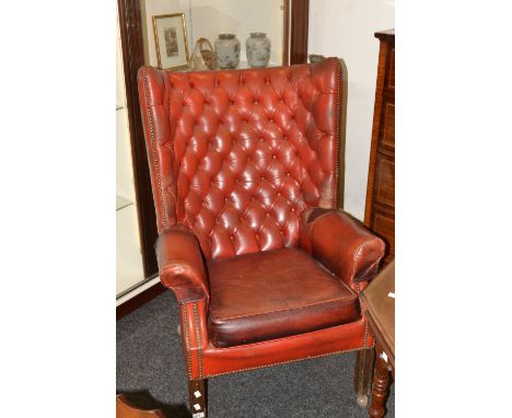 A leather wingback armchair, button back upholstery in red, square mahogany legs