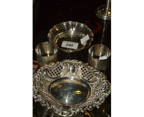 A pair of silver napkin rings, engine turned;  a silver pierced and embossed shaped oval pin dish;  another (4)