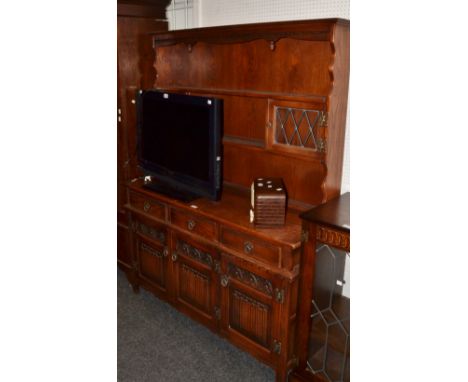 An oak Old Charm dresser, glazed leaded lights, carved panel doors