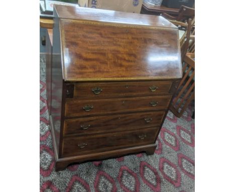 A reproduction of an Edwardian mahogany bureau with four graduated long drawer, on bracket feet, 99cm h x 75.5cm w x 40.5cm d