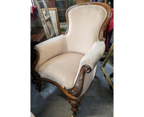 A Victorian rosewood upholstered armchair a/f, carved decoration to the arm supports and French cabriole front legs, on brass
