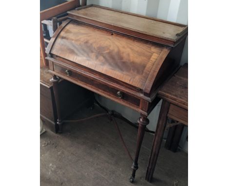 An Edwardian mahogany crossbanded desk having a bow front fall flap (unable to open) above a frieze drawer and on reeded tape