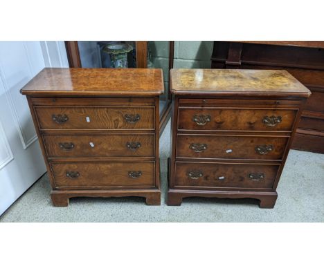 A pair of reproduction burr walnut veneered chest of drawers, each having a brush slide above three drawers on bracket shaped
