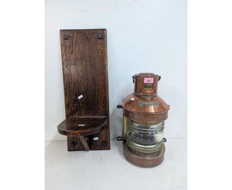 A late 19th/early 20th century marine masthead lantern with brass and copper body and ribbed glass shade, along with an oak w