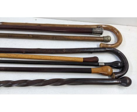 A group of walking sticks to include an ebonised stick with an engraved white metal rimLocation:If there is no condition repo
