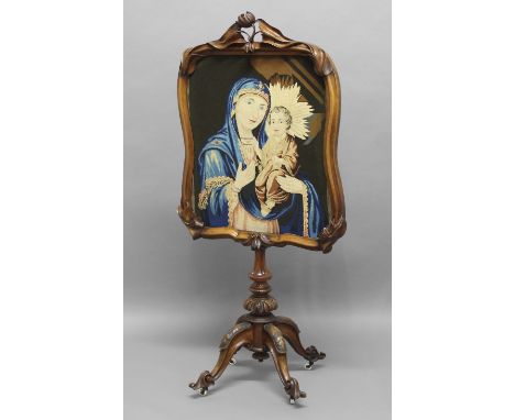 VICTORIAN NEEDLEWORK FIRE SCREEN, depicting Madonna and Child, the frame with floral carving on a knopped column above a scro