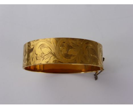 A 9 ct Gold Metal Core Bangle Bracelet, the bracelet engraved with a floral design. 